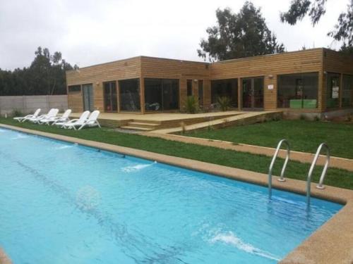 uma casa com piscina em frente a um edifício em Depto Costa Algarrobo Norte em Yeco