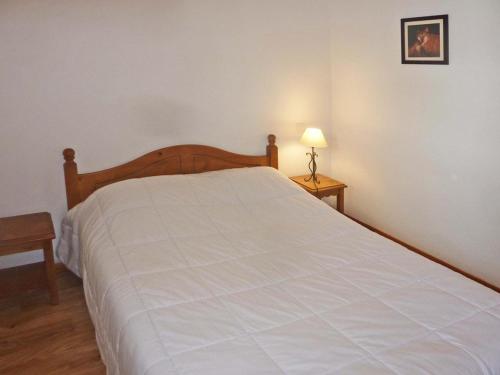 - une chambre avec un grand lit et un couvre-lit blanc dans l'établissement Charmant T2, Accès Piscine, Sauna, Ski-In/Out, Balcon Ouest, 6 Pers - Les Orres 1800 - FR-1-322-343, aux Orres