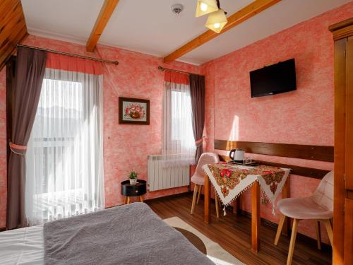 a bedroom with a bed and a table and a television at Willa Roztoka & SPA - idealne miejsce dla Twojej rodziny in Bukowina Tatrzańska
