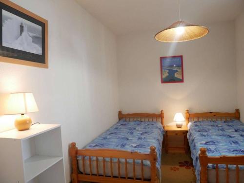 ein Schlafzimmer mit 2 Betten, einem Nachttisch und einer Lampe in der Unterkunft Appartement Étel, 2 pièces, 5 personnes - FR-1-479-37 in Étel