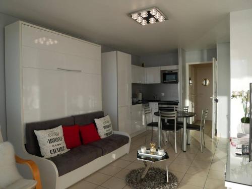 uma sala de estar com um sofá e uma mesa em Studio Quiberon, 1 pièce, 3 personnes - FR-1-478-41 em Quiberon