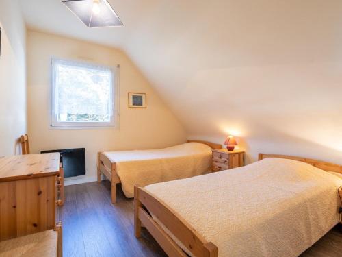 een slaapkamer met 2 bedden, een tv en een raam bij Villa Carnac, 5 pièces, 8 personnes - FR-1-477-50 in Carnac