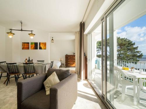 d'un salon avec un canapé et d'un balcon avec une table. dans l'établissement Carnac - Appart 3 pièces + coin couchage, 78m², accès direct plage, animaux admis, parking couvert - FR-1-477-88, à Carnac