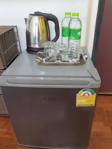 une glacière avec des bouteilles d'eau et des verres en haut. dans l'établissement Doodle Lodge Chiang Mai, à Chiang Mai