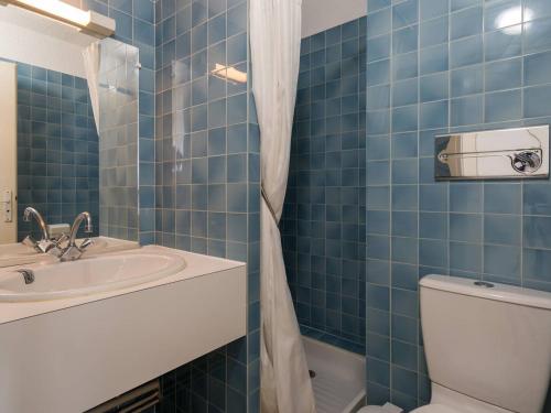 La salle de bains est pourvue de carrelage bleu, d'un lavabo et de toilettes. dans l'établissement Carnac - Studio cabine 4 pers, 28m², vue mer, parking, animaux acceptés - FR-1-477-117, à Carnac
