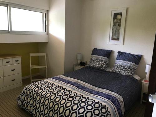 une chambre avec un lit avec des oreillers bleus et une fenêtre dans l'établissement Appartement T3 tout confort avec terrasse et parking sécurisé - 6 couchages - Argelès-sur-Mer - FR-1-388-167, à Argelès-sur-Mer