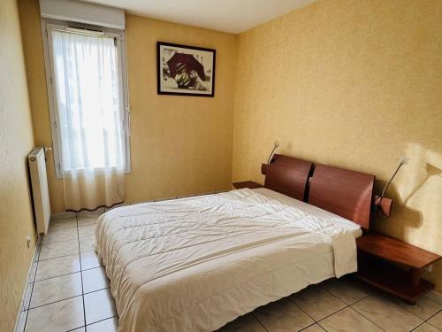 een slaapkamer met een groot bed in een kamer met een raam bij Appartement Cambo-les-Bains, 3 pièces, 4 personnes - FR-1-495-18 in Cambo-les-Bains