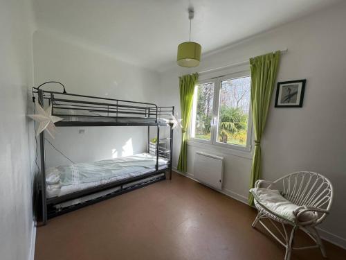 a bedroom with a bunk bed and a chair and a window at Maison Cambo-les-Bains, 4 pièces, 4 personnes - FR-1-495-48 in Cambo-les-Bains