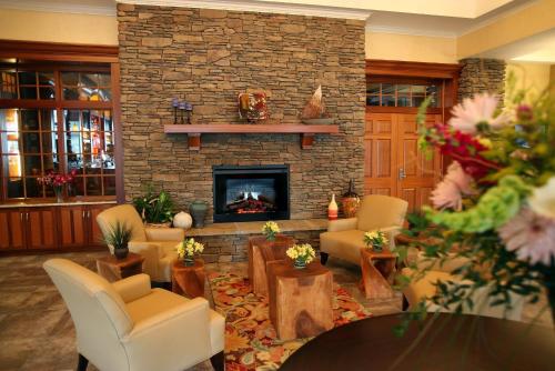 a living room with a fireplace and a table and chairs at Watkins Glen Harbor Hotel in Watkins Glen