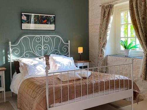 a bedroom with a bed with a metal frame at La Lande in Bricquebec