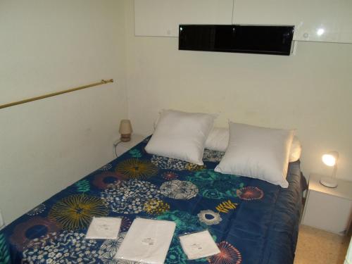 un lit avec une couette bleue et deux oreillers blancs dans l'établissement Appartement climatisé avec balcon, proche des Thermes et de l'Étang de Thau - FR-1-503-57, à Balaruc-les-Bains