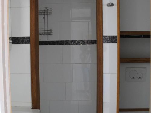 une douche avec une porte vitrée dans une salle de bain dans l'établissement Appartement climatisé avec balcon, proche des Thermes et de l'Étang de Thau - FR-1-503-57, à Balaruc-les-Bains