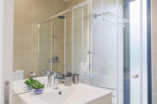 a bathroom with a white sink and a shower at O Nosso Refúgio in Água de Pau