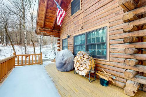 a wooden cabin with a pile of logs on a deck at 262 Ghia Farm Road in Ludlow