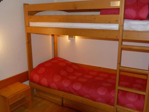 Cette chambre dispose de lits superposés avec 2 lits superposés et un matelas rouge. dans l'établissement Duplex 2 Pièces 6 Pers, Ski aux Pieds, Charmettoger Arc 1800, Proche Transarc, Équipements Confort - FR-1-411-607, à Bourg-Saint-Maurice