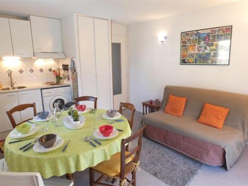 Il dispose d'une cuisine et d'un salon avec une table et un canapé. dans l'établissement Appartement T3 pour 6 à Saint-Lary-Soulan avec balcon, casier à ski, parking, ascenseur - FR-1-457-266, à Saint-Lary-Soulan