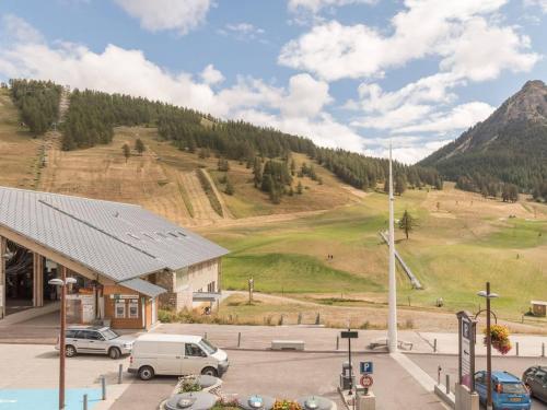 - un parking avec des voitures garées devant une montagne dans l'établissement Appartement cosy 4/5 pers, centre Montgenèvre - FR-1-330D-72, à Montgenèvre
