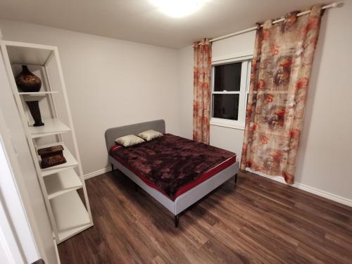 a small bedroom with a bed and a window at Beautiful 3 bedroom house in Ottawa