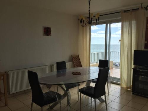 une salle à manger avec une table et des chaises et l'océan dans l'établissement Duplex T3 6 pers, plage à 2 pas, parking privé - FR-1-81-497, au Barcarès