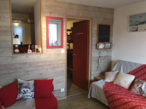 een woonkamer met een bank en een rode deur bij Studio La Mongie, 1 pièce, 5 personnes - FR-1-404-228 in La Mongie
