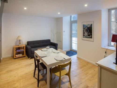 un salon avec une table et un canapé dans l'établissement Duplex rénové 2 chambres avec wifi, cuisine équipée et local ski, en centre-ville de Cauterets - FR-1-401-179, à Cauterets