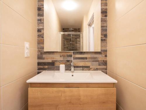 ein Badezimmer mit Waschbecken und Spiegel in der Unterkunft Appartement central 4-9 personnes avec parking à Cauterets - FR-1-401-181 in Cauterets