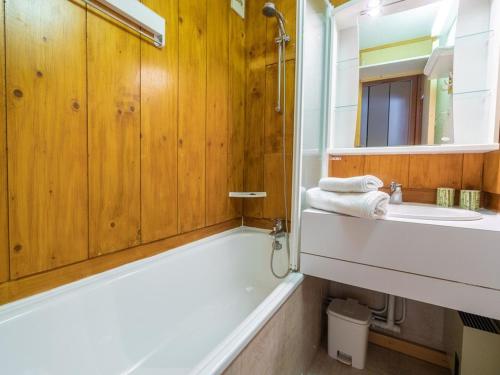 Un baño con bañera, lavabo y espejo. en Appartement cosy 4 pers, Animaux acceptés, Parking dispo - FR-1-291-845, en Valmorel