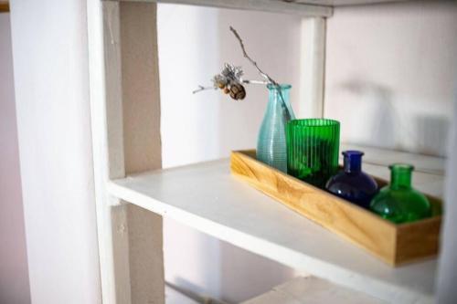 a shelf with vases and a bee on it at Casa para 4 pers. con entrada de auto y parrillero in Piriápolis