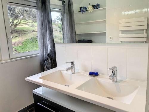 une salle de bain avec deux lavabos et une fenêtre dans l'établissement Superbe maison avec jardin, proche plage, chiens admis - FR-1-542-25, à Trébeurden