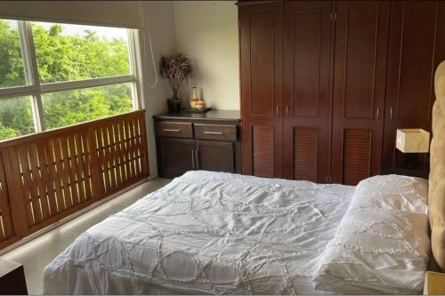 a bedroom with a white bed and a window at Lovely 3 bedroom condo with pool in Ixtapa