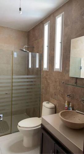 a bathroom with a toilet and a shower and a sink at Lovely 3 bedroom condo with pool in Ixtapa