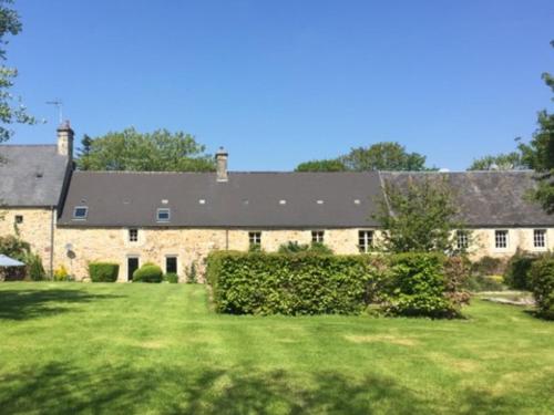 a large brick building with a large yard at La Lande in Bricquebec