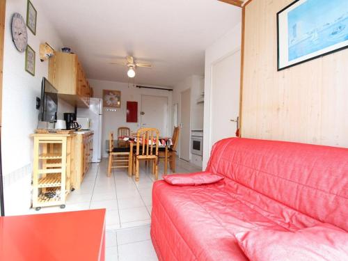 un salon avec un canapé rouge et une table dans l'établissement T2 avec jardinet, cuisine équipée, parking privatif - FR-1-553-57, à Balaruc-les-Bains