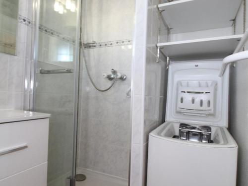 une salle de bain avec douche et machine à laver dans l'établissement Grand Studio Climatisé avec Terrasse et Parkings, Proche des Thermes - FR-1-553-106, à Balaruc-les-Bains