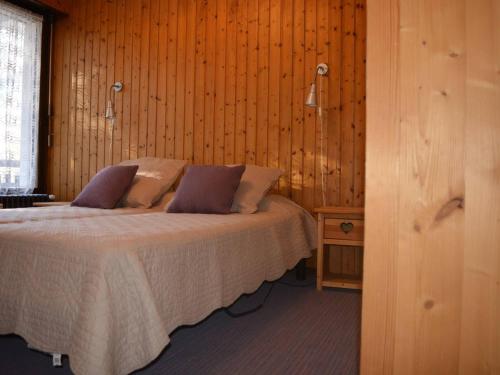- une chambre avec un lit et un mur en bois dans l'établissement Appartement Le Grand-Bornand, 3 pièces, 6 personnes - FR-1-241-222, au Grand-Bornand