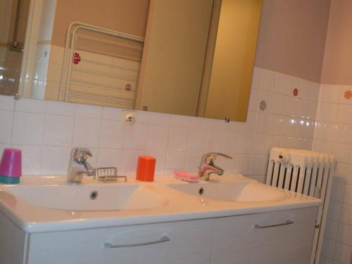 un lavandino in bagno con due rubinetti e uno specchio di Appartement Le Grand-Bornand, 3 pièces, 6 personnes - FR-1-241-222 a Le Grand-Bornand