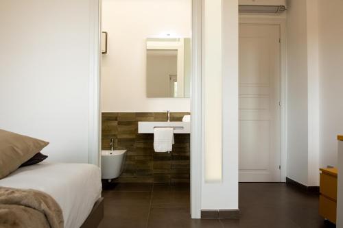 ein Bad mit einem Bett, einem Waschbecken und einem Spiegel in der Unterkunft CinqueStanze Affittacamere in Messina