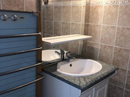 La salle de bains est pourvue d'un lavabo blanc et d'un mur bleu. dans l'établissement Grand T4 au Barcarès avec Vue Mer et Parking - 3 Chambres, Terrasse, Proche plage - FR-1-81-525, au Barcarès