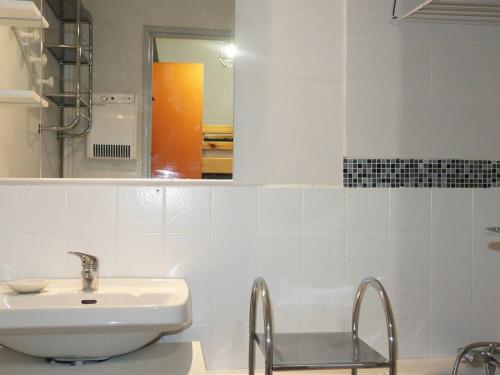 une salle de bain blanche avec un lavabo et un miroir dans l'établissement Grand studio confort 4 pers au centre, proche commerces et pistes - FR-1-322-409, aux Orres
