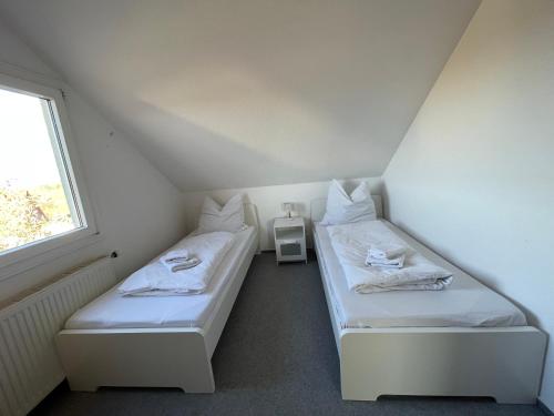two beds in a small room with a window at Ferienwohnung Bördeblick in Barby