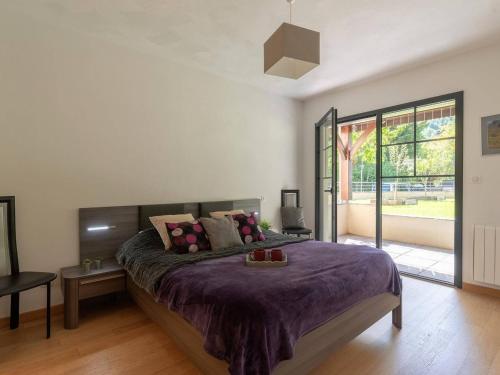 une chambre avec un grand lit avec une couverture violette dans l'établissement Superbe appartement pour 6 avec terrasse, jardin privé, Wi-Fi gratuit et parkings - Saint-Lary Centre - FR-1-296-320, à Saint-Lary-Soulan