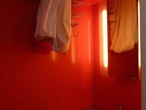 ein Bad mit einer roten Wand und einem Spiegel in der Unterkunft Studio confortable pour 3 pers, balcon, Arcs 1800 - FR-1-411-681 in Bourg-Saint-Maurice