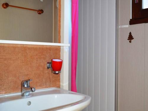La salle de bains est pourvue d'un lavabo et d'une coupe rouge. dans l'établissement Chalet familial 2 pièces pour 4 pers. à 500m des pistes avec terrasse et équipements modernes - FR-1-592-23, à Bolquère-Pyrénées 2000