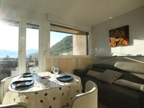 d'un salon avec une table à manger polka et un canapé. dans l'établissement Studio rénové 4 pers à Saint-Chaffrey avec balcon, classé 3 étoiles - FR-1-330E-117, à Saint-Chaffrey