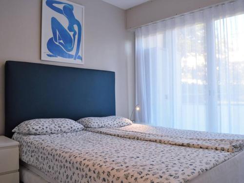 a bedroom with a bed with a large window at Appartement Bormes-les-Mimosas, 3 pièces, 6 personnes - FR-1-251-371 in Bormes-les-Mimosas