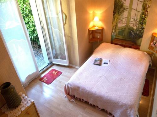- une chambre avec un lit et un livre dans l'établissement Charmant T2 RDC avec Jardinet et Parking, Proche Thermes et Commerces - FR-1-313-152, à Luchon