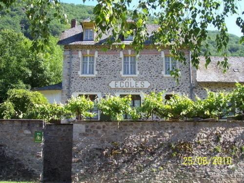 a building with a sign on the side of it at Gite ecole in Soursac