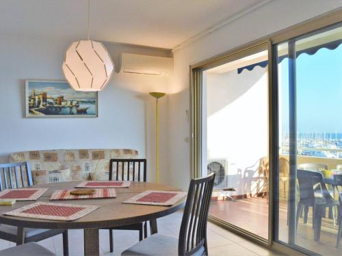 une salle à manger avec une table et un balcon dans l'établissement Appartement T2 climatisé, terrasse, plage à 3 couchages - FR-1-251-379, au Lavandou