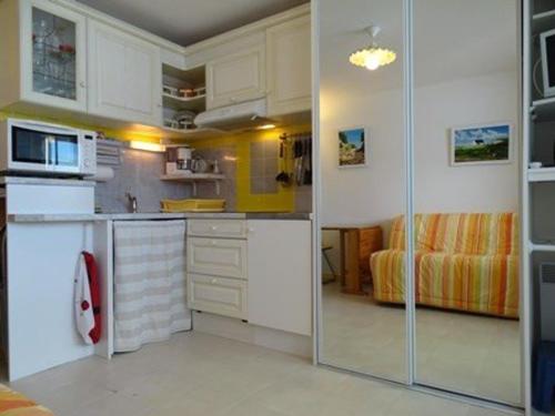 une cuisine avec des placards blancs et une porte coulissante en verre. dans l'établissement Studio 4 pers. au pied des pistes avec balcon - Arette - FR-1-602-7, à Arette