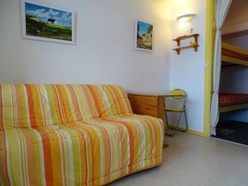 un salon avec un canapé rayé jaune et orange dans l'établissement Studio 4 pers. au pied des pistes avec balcon - Arette - FR-1-602-7, à Arette